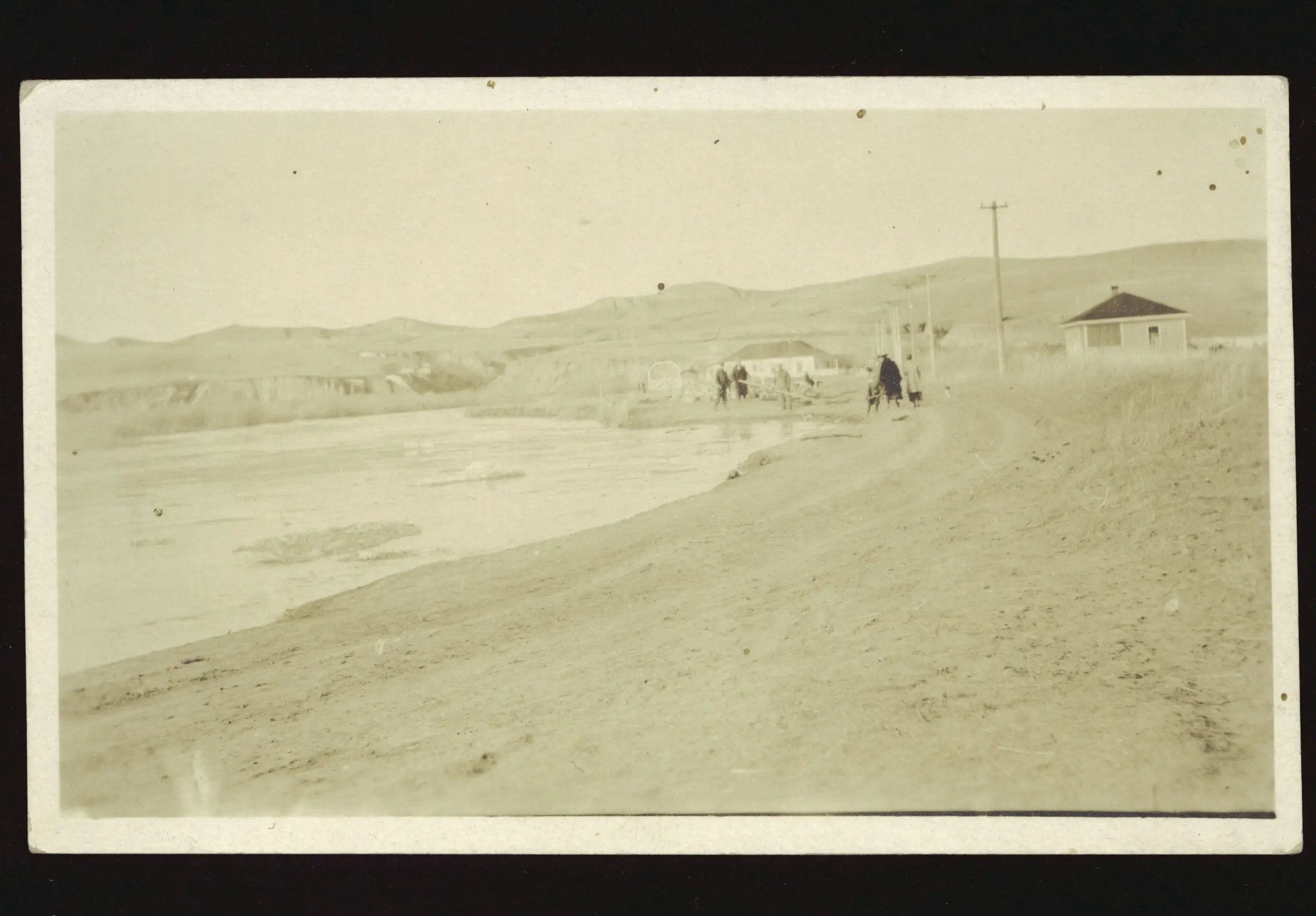 Flooded creek beside a dirt road near Eastend