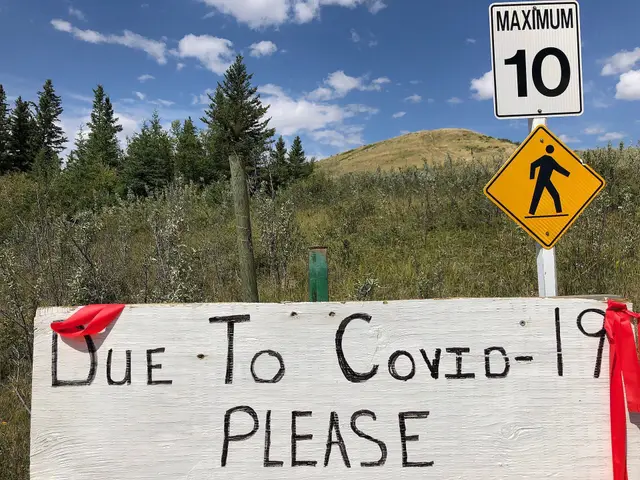 Covid-19 sign by trail with hill